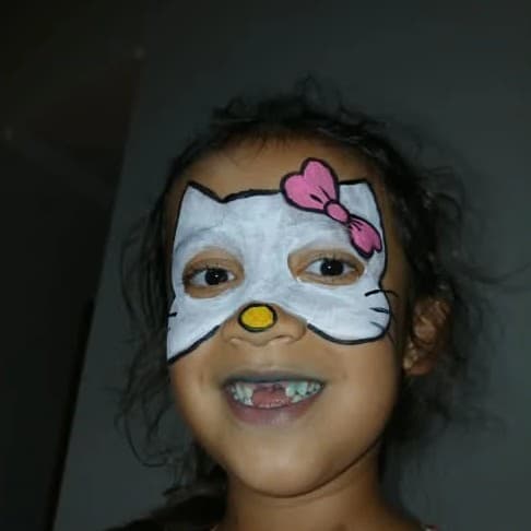 Criança com pintura de rosto da Hello Kitty feita pela equipe Batutinhas